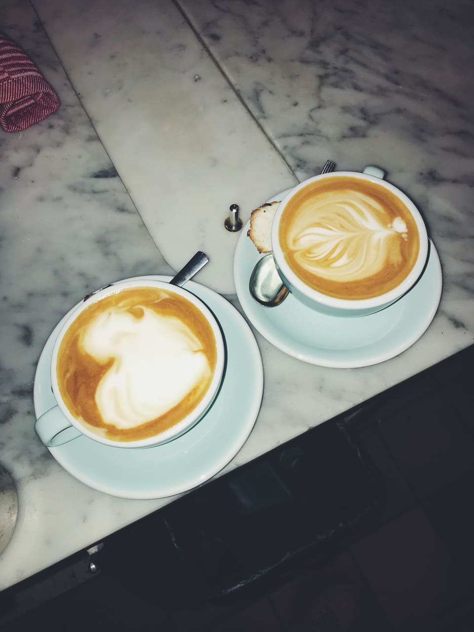 Deux cappuccinos au latte art, sur une table en marbre